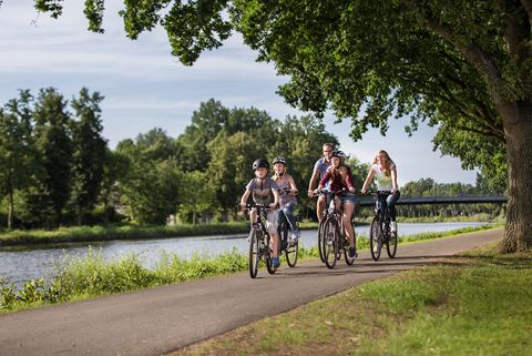 Familie macht eine Radtour am Kanal