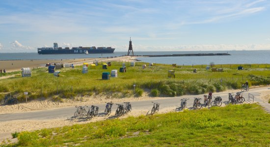 Landschap aan de Elbe bij Cuxhaven-Döse met Kugelbake, containerschip, fietsen en strandstoelen., © TMN/Dieter Schinner