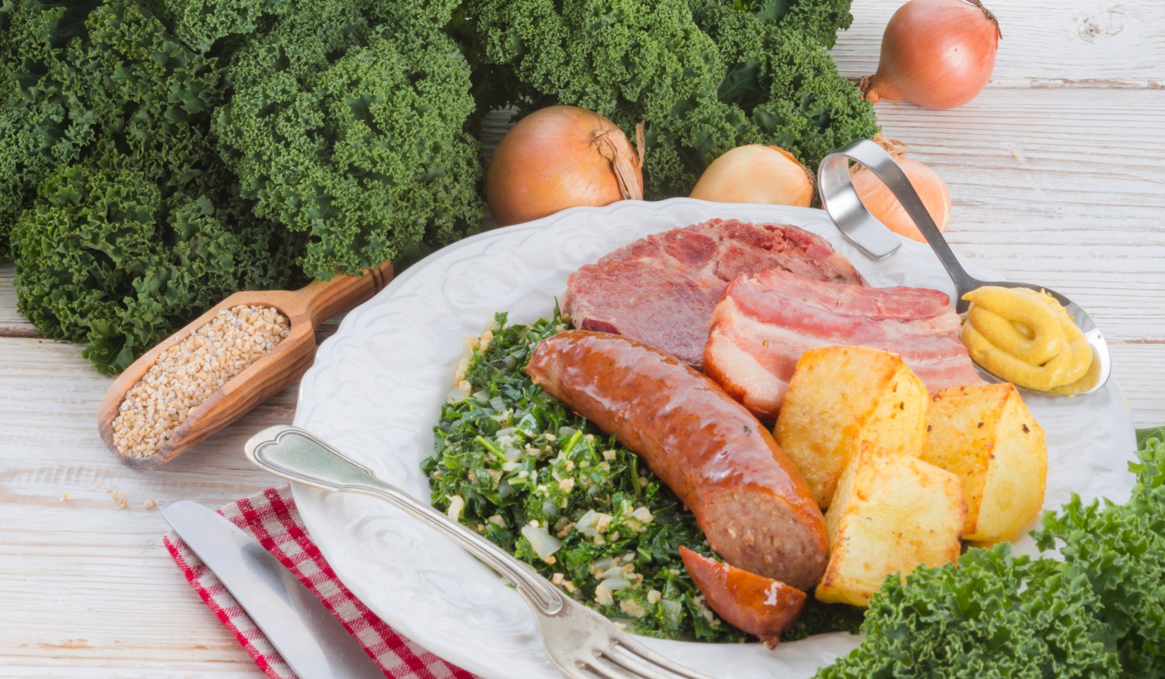 Het bord is gevuld met boerenkool, pinkel, aardappelen en gerookt varkensvlees., © Fotolia - Dzinnik Darius