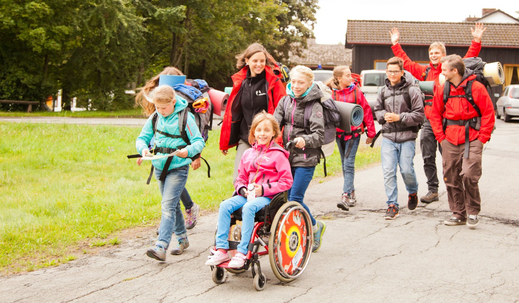 Kinderen en volwassenen maken een tour door de Harz. Een meisje zit in een rolstoel en glimlacht., © erlebnistage Harz / Markus Hennemann