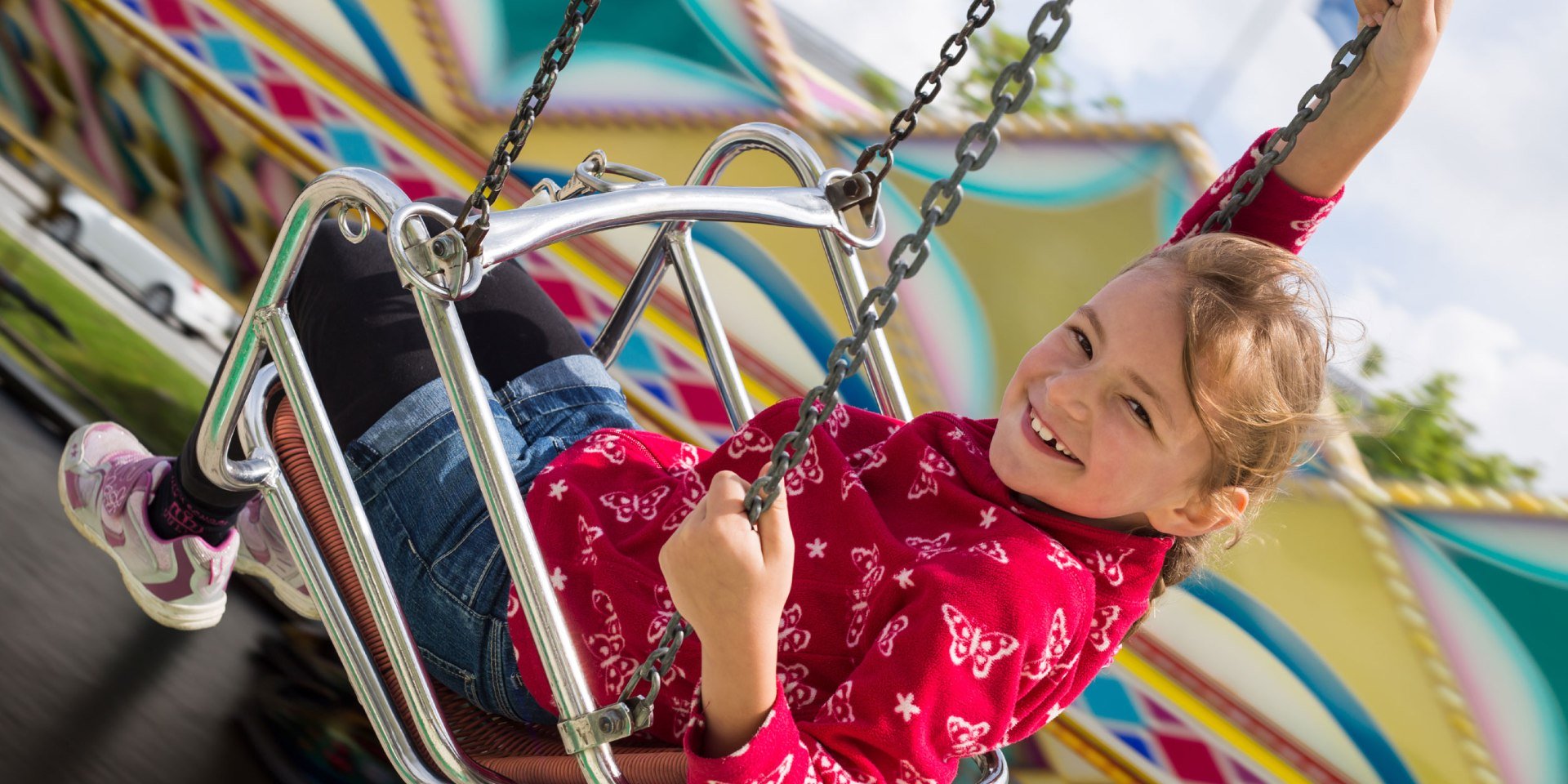 Een meisje heeft plezier in de kettingcarrousel, © Fotolia / Stefanie B.