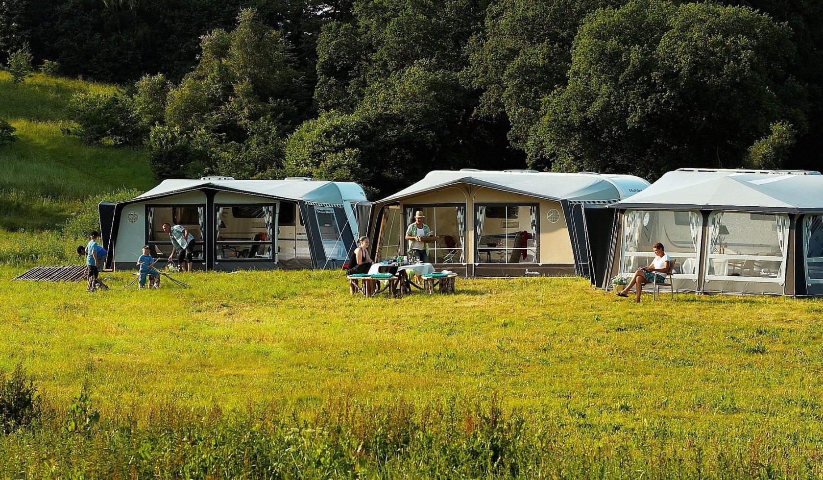 Drie tenten staan voor stacaravans op een camping, © TMN/pixabay