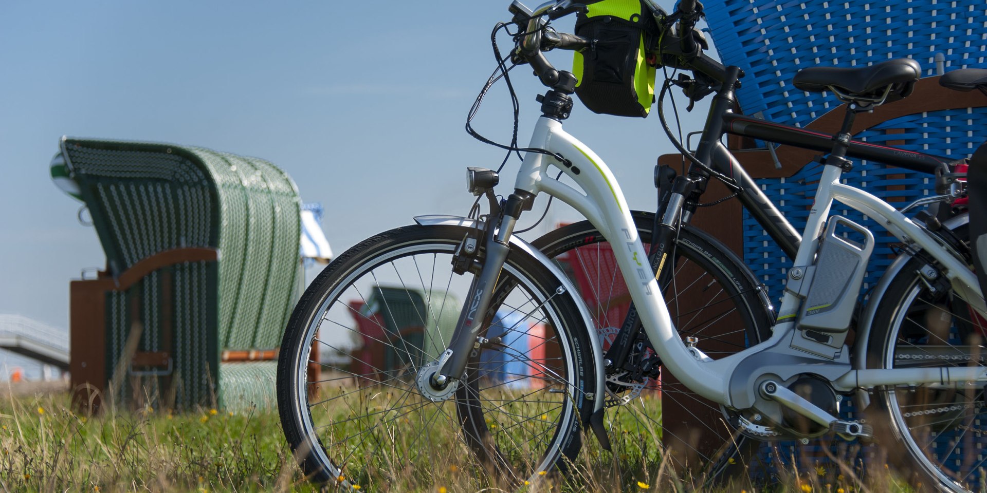 Ebikes leunen op een strandstoel, © Cuxland-Tourismus / Bernd Otten