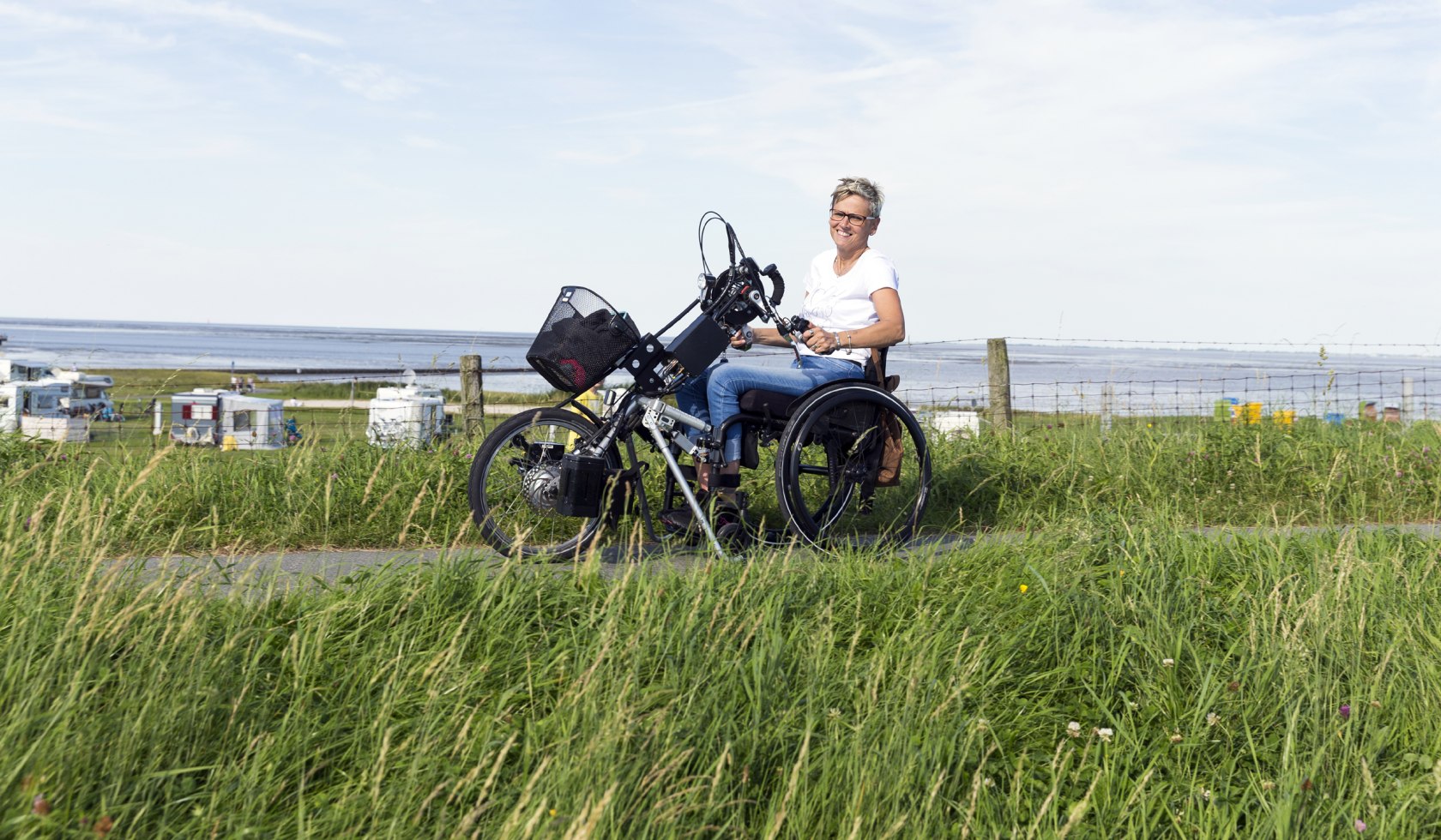 Vrouw met handfiets op de barrièrevrije strandpromenade, © Tourismus-Service Butjadingen GmbH &amp; Co. KG