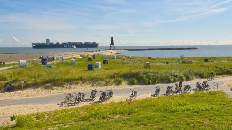 Landschap aan de Elbe bij Cuxhaven-Döse met Kugelbake, containerschip, fietsen en strandstoelen., © TMN/Dieter Schinner