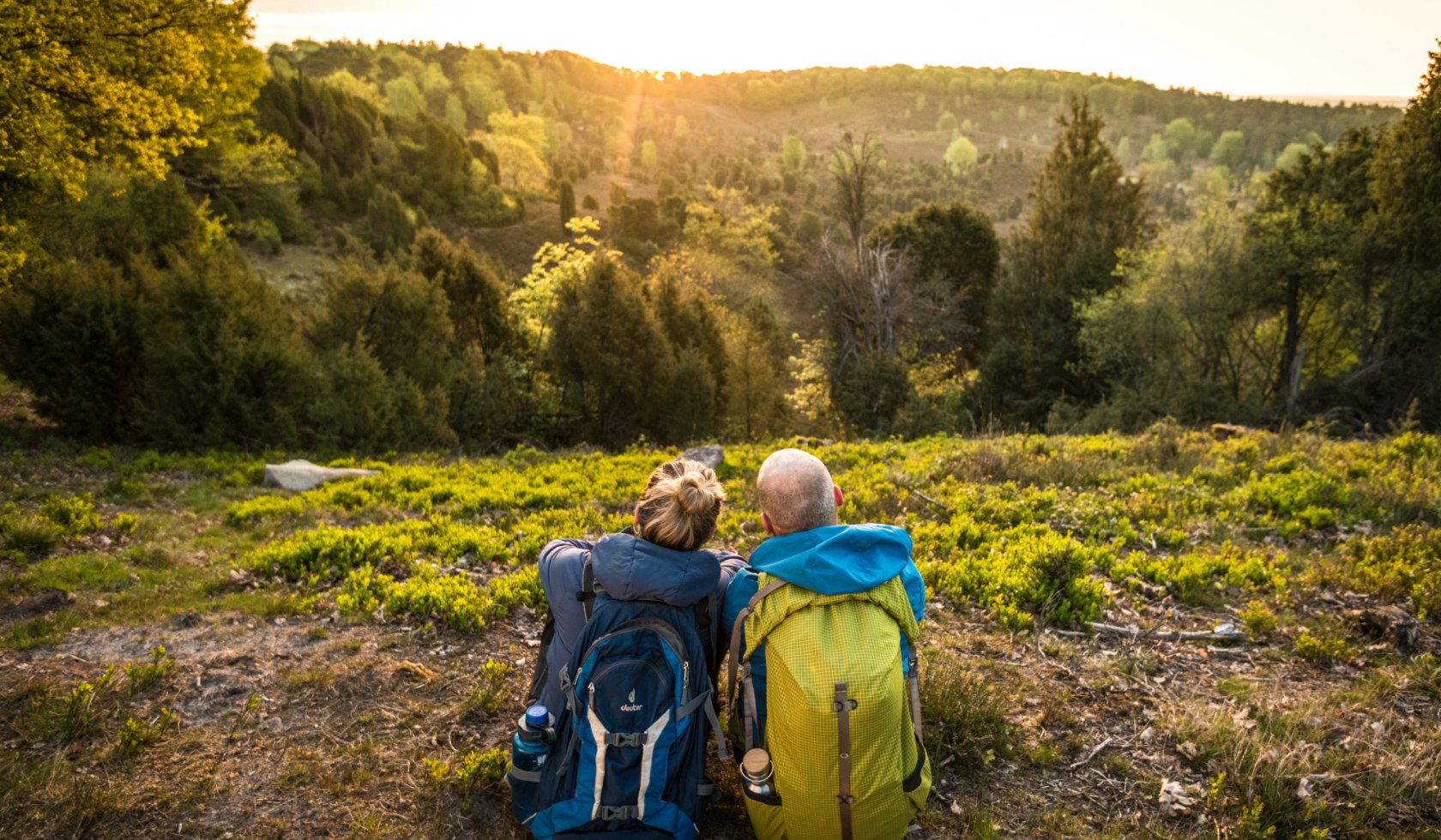 twee wandelaars van achteren gezien tijdens een pauze in de Lüneburger Heide , © Lüneburger Heide GmbH