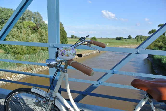 Uitzicht vanaf de Amdorf-brug op de voorgrond een fiets, © Ostfriesland Tourismus GmbH / www.ostfriesland.de
