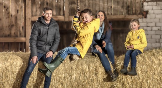 Jongen springt met touw en familie staat achter, © TMN