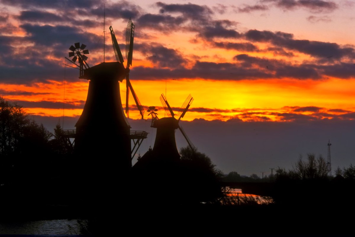 De tweelingmolens van Greetsiel aan het oude Greetsieler Sieltief zijn een herkenningspunt van de populaire plaats aan de Noordzeekust., © Dieter Schinner