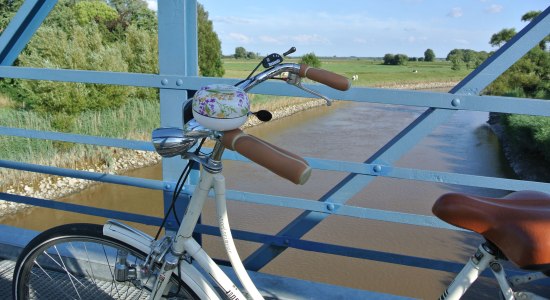 Uitzicht vanaf de Amdorf-brug op de voorgrond een fiets, © Ostfriesland Tourismus GmbH / www.ostfriesland.de