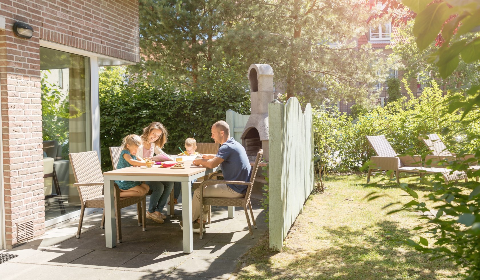 Gezin zittend op het terras voor het vakantiehuis., © Center Parcs