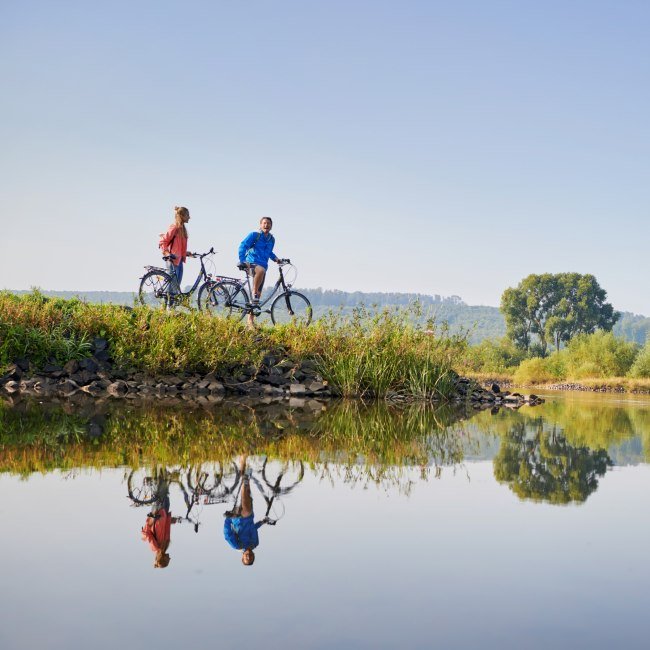 Paar met fietsen neemt een pauze bij de Weser, © DZT/Jens Wegener